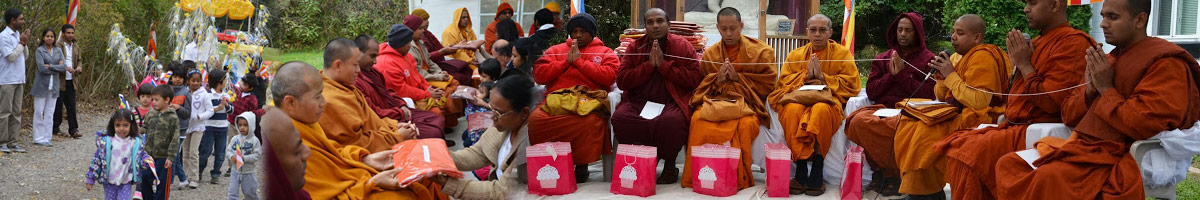 Buddhist monks seated in an outdoor ceremony.