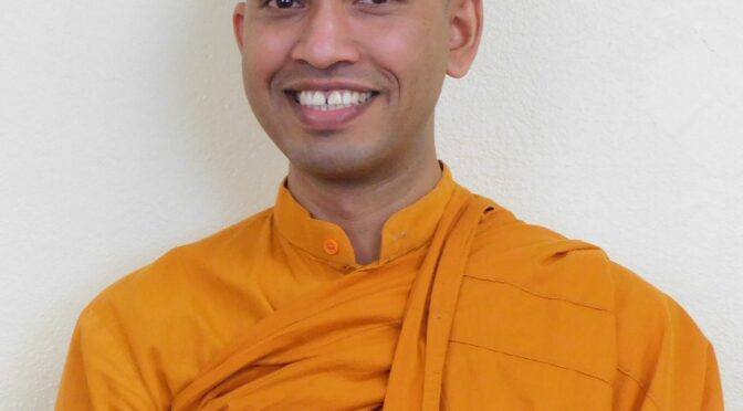 Smiling person in an orange robe.